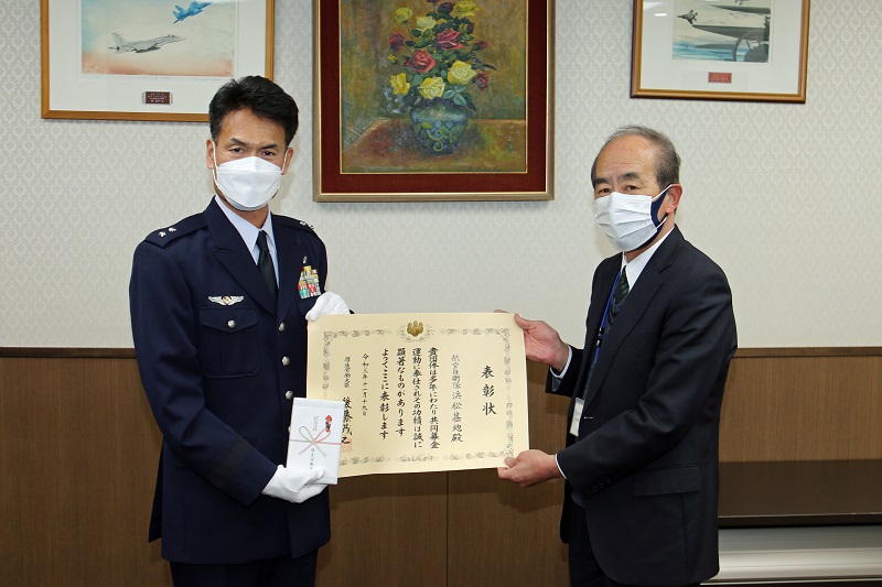 感謝状を手に持つ1空団司令の画像