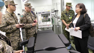 Kazakhstan military members are briefed on Japanese mobile hospital technology.