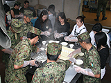新潟県中越沖地震において地元のボランティアといっしょに炊き出しを行う隊員