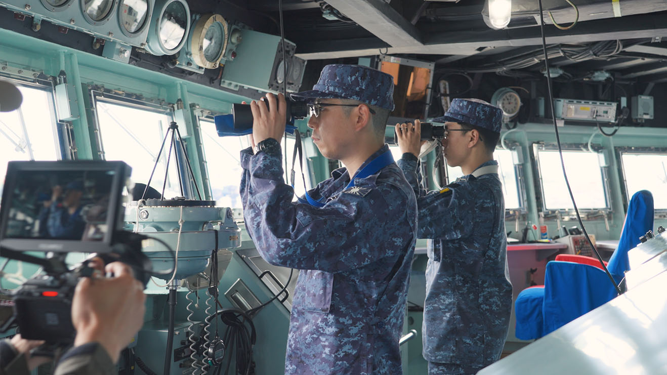 艦橋で周囲を監視する海上自衛官