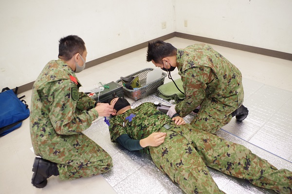 戦傷治療集合訓練時の患者観察中の写真です。