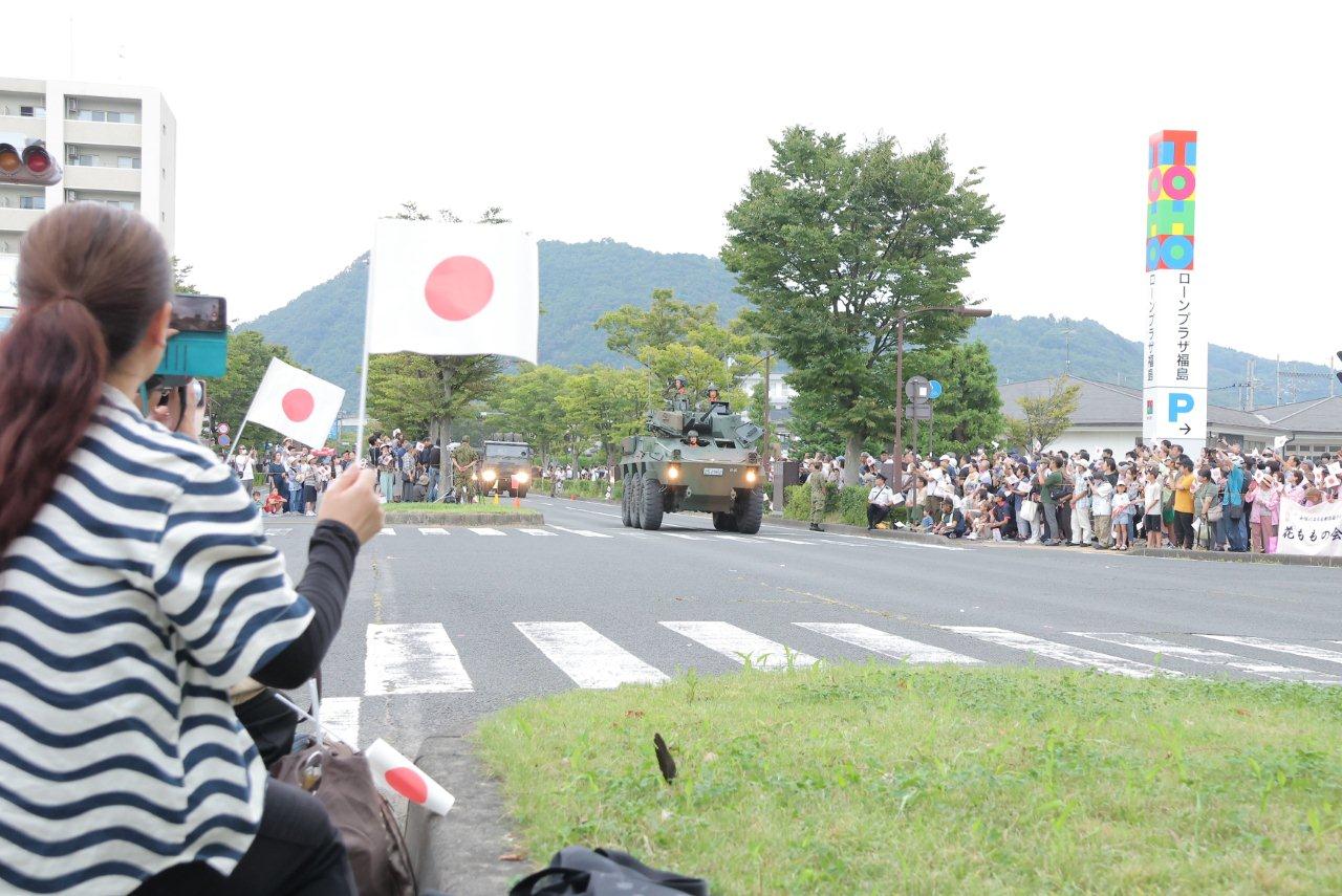 国旗を振る沿道の方々