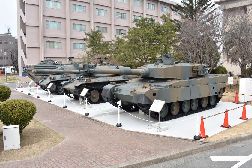 写真：９０式戦車やＡＡＶ７（水陸両用車）等の装備品の前で記念撮影