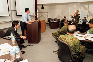 机上訓練で参加者の発表を聞く筆者（左から2人目）