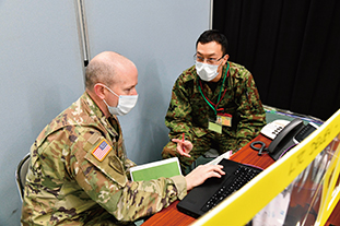 米陸軍連絡チーム長と調整する筆者(右側)