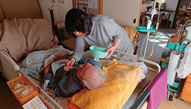 父の介護をする妻(口腔内清拭)