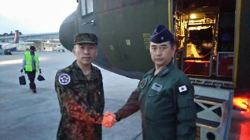 >インドネシア国際緊急援助空輸隊司令（右：太田１空佐）と合流し、握手するインドネシア現地調整所長（左：小出１陸佐）