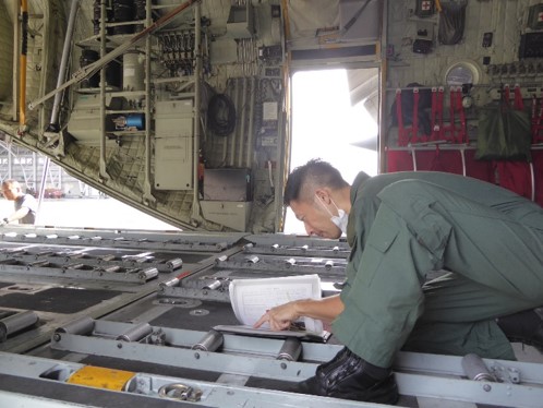 >Ｃ－１３０Ｈ輸送機機内で書類を点検する搭乗員