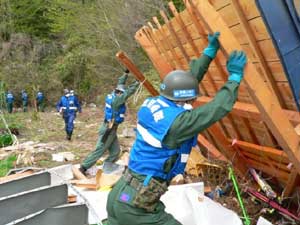 捜索のために瓦礫を持ち上げる隊員