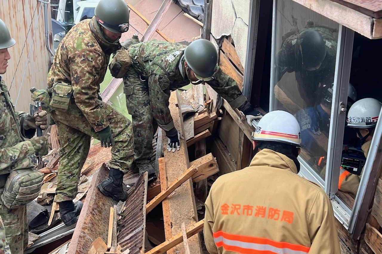 鳳至町において消防隊員と共同して人命救助を行う第14普通科連隊