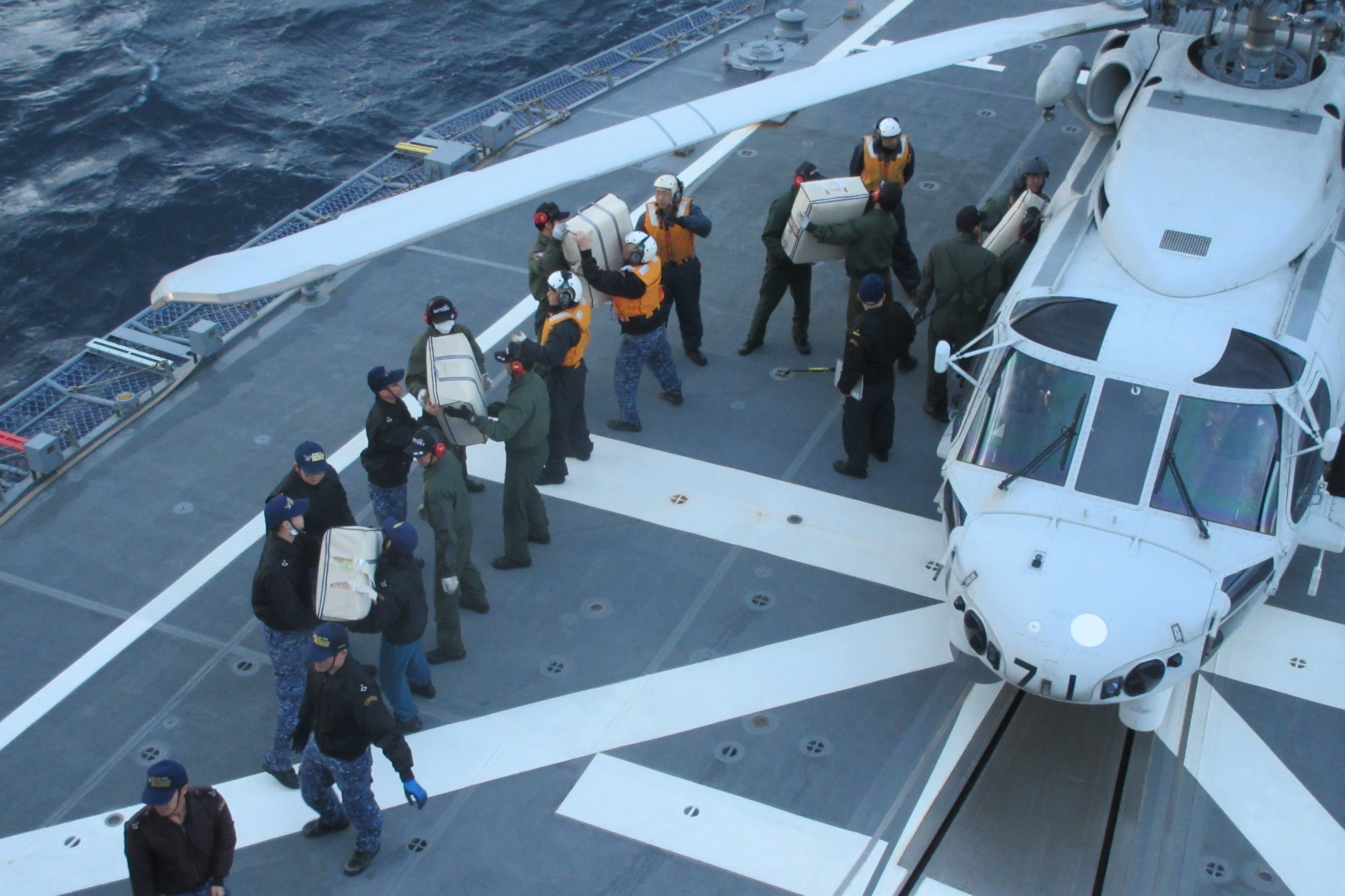 護衛艦「すずなみ」艦上において救援物資の搭載を行う海自隊員