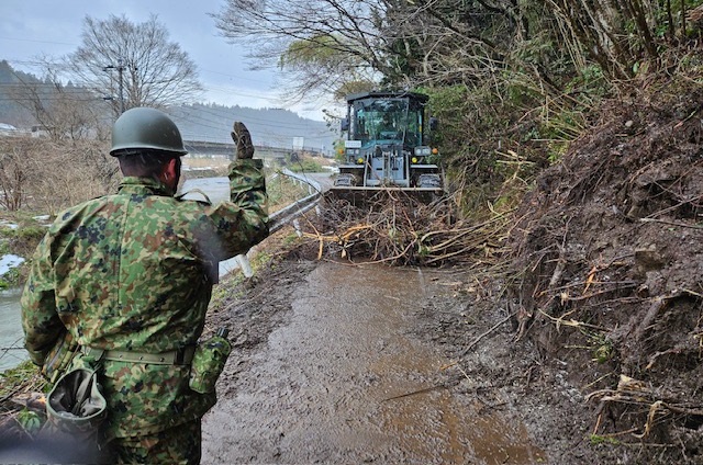 道路啓開のためバケットにより倒木伐採