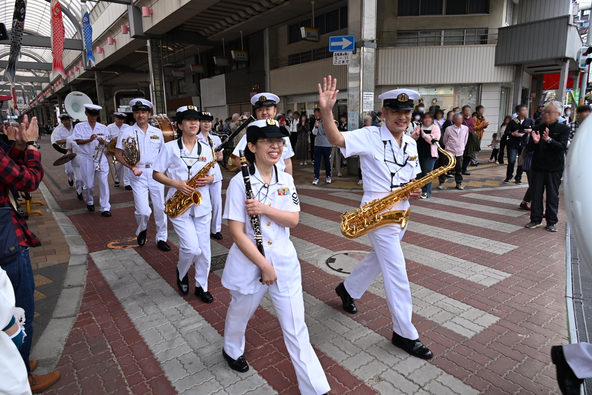 パレードを終えて沿道の観客に笑顔で手を振る音楽隊員たち