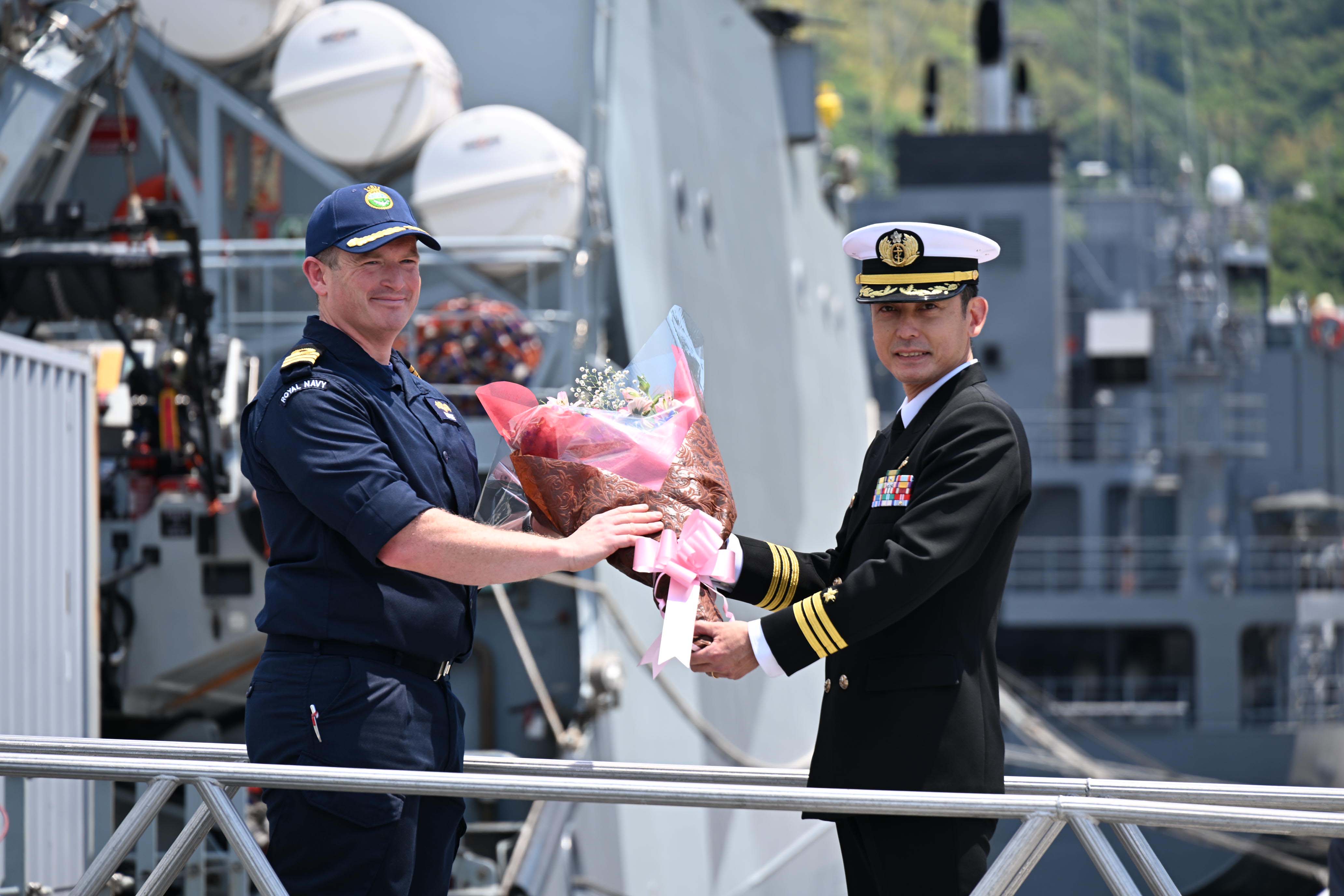 笑顔で花束を手にするスペイ艦長としまかぜ艦長