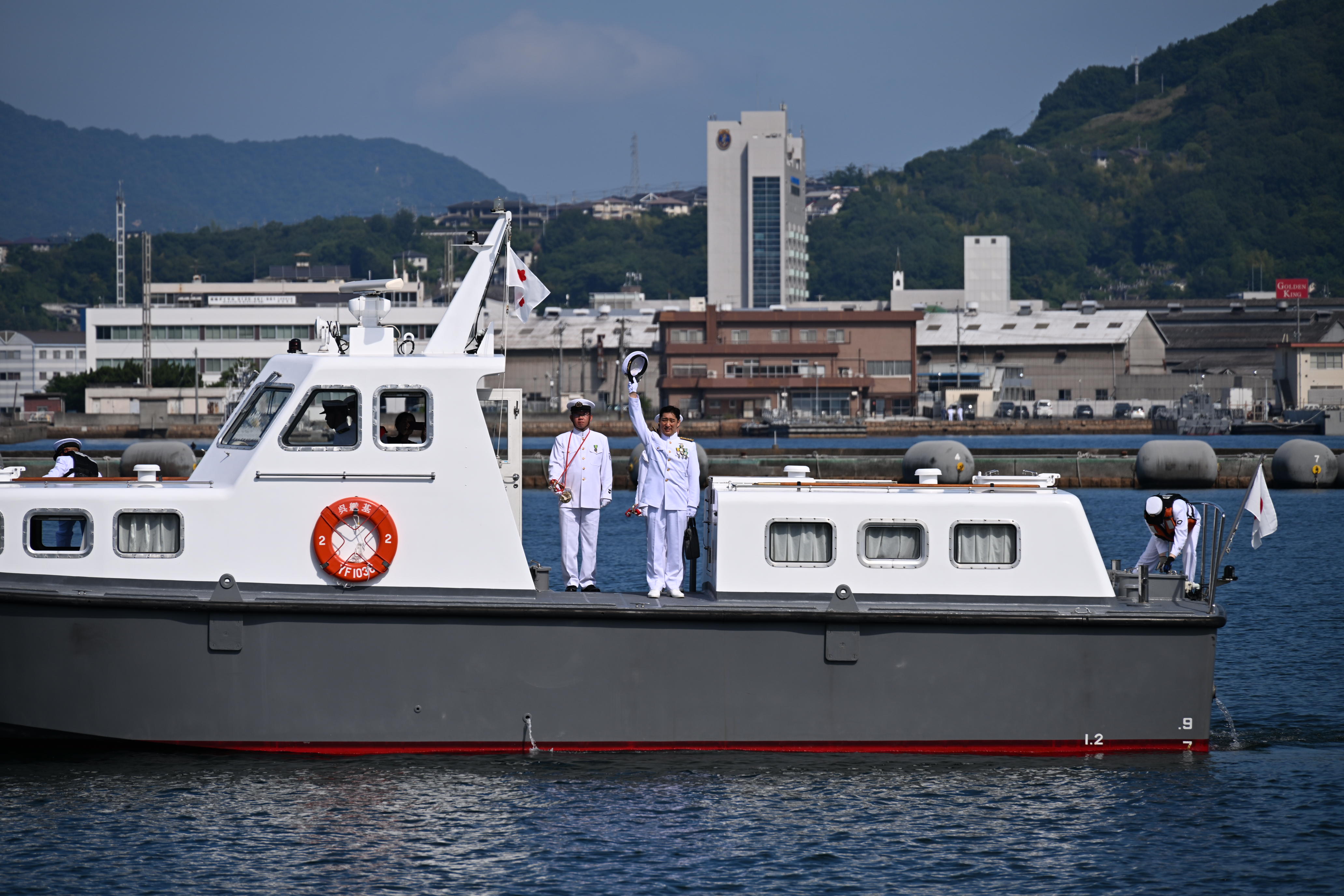 隊員たちの帽振れに応える松本海将