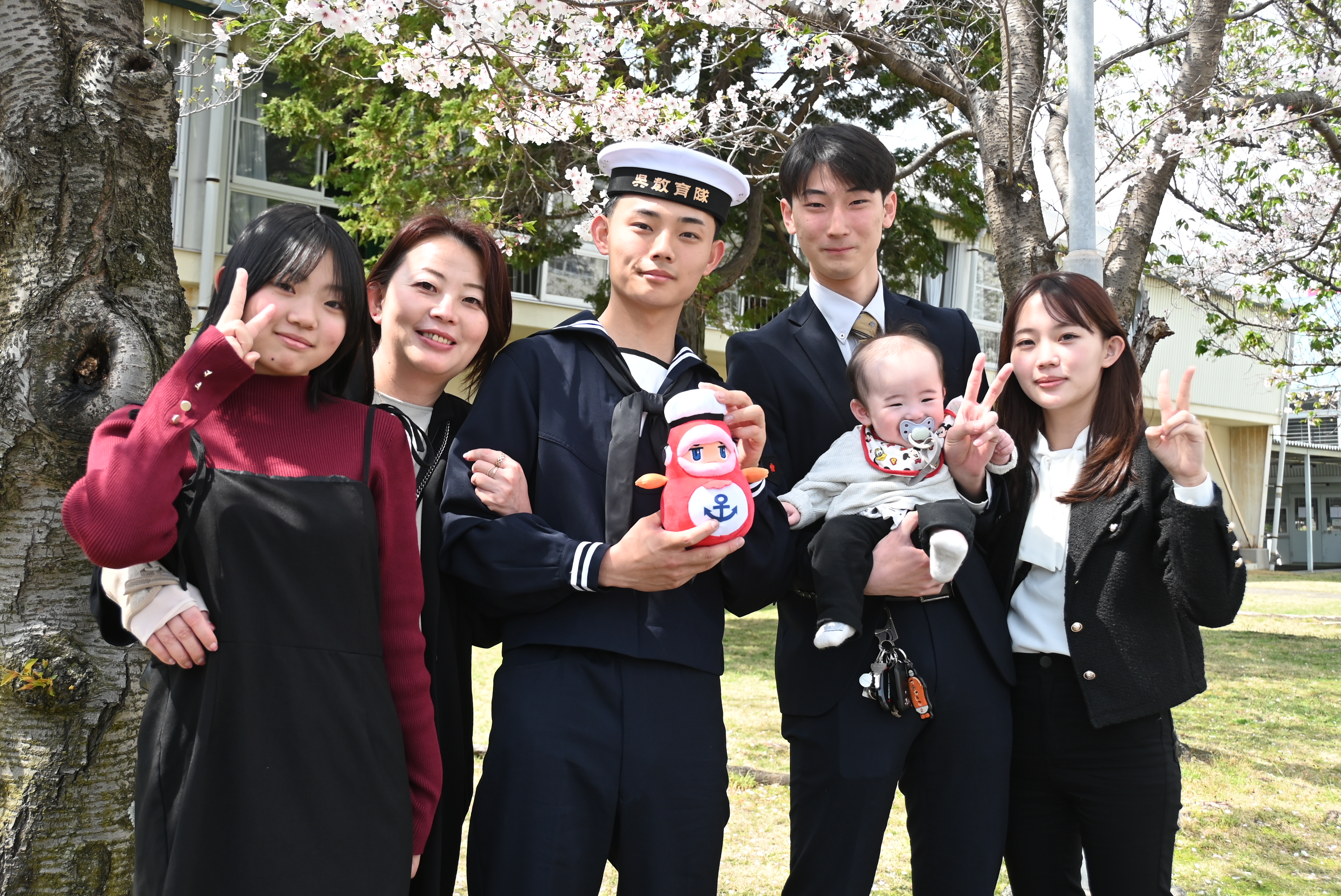 桜の下で笑顔の新入隊員とご家族＋鯛くん