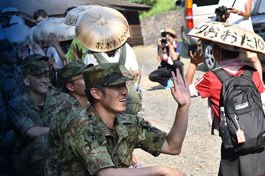 写真:子どもとハイタッチをする自衛官