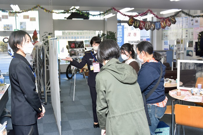 案内所で案内する女性自衛官と見学する参加者