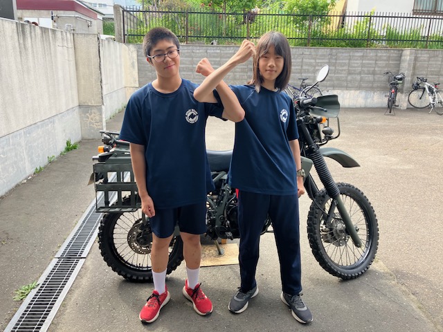偵察用バイクをバックに記念撮影